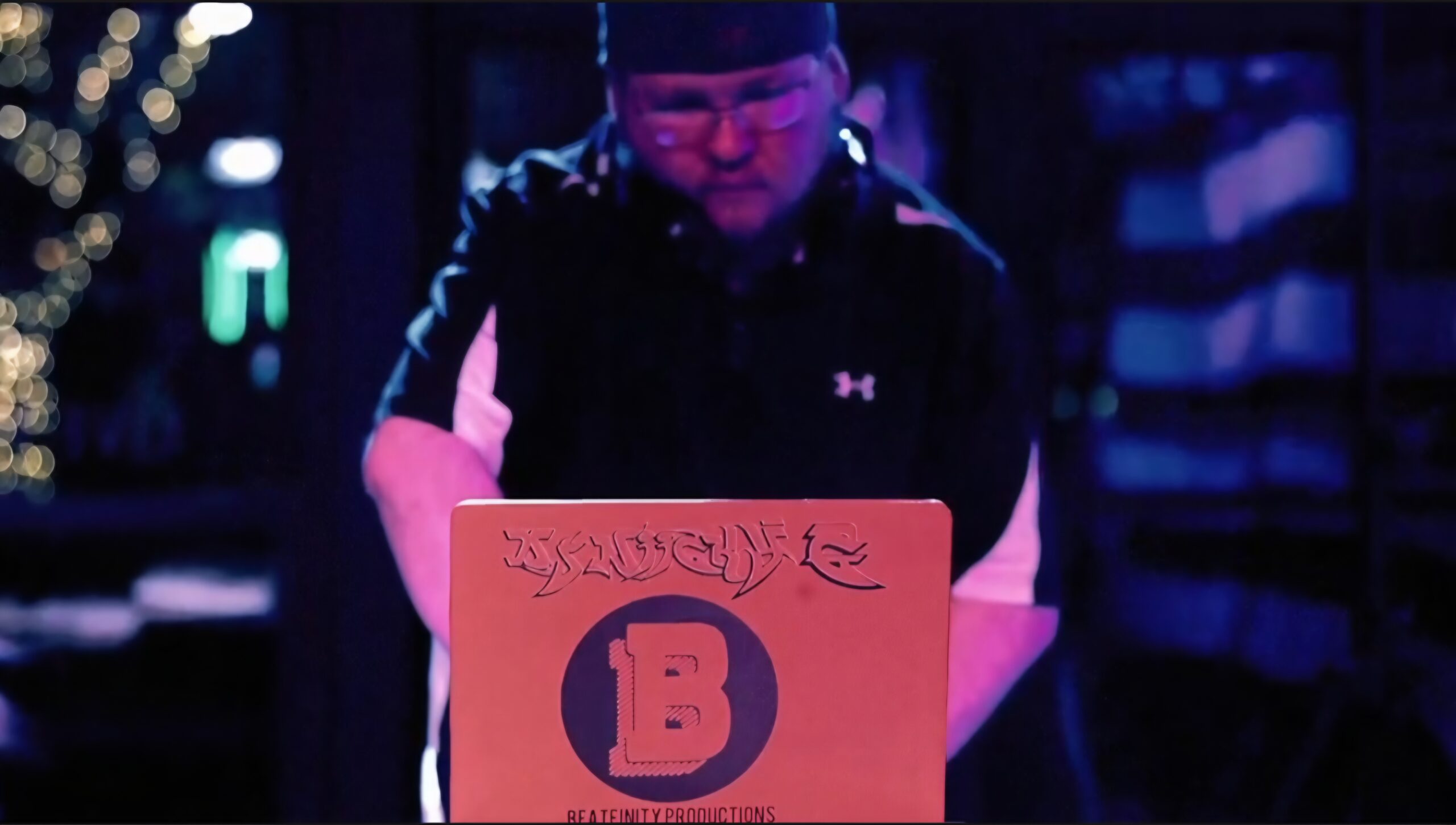 DJ Niicky G plays a Pink Pony Club mix from his laptop adorned in his logo and the Beatfinity logo.